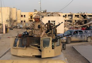 Iraqi security forces and Shiite fighters are deployed during a military operation to regain control of the university of Tikrit, 80 miles (130 kilometers) north of Baghdad, Iraq, Monday, Dec. 8, 2014.