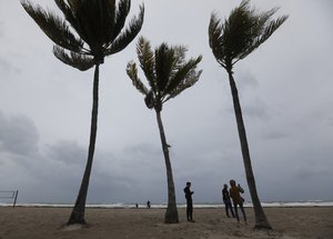 Beach goers check out churning waves and high winds along Hollywood Beach, Saturday, Sept. 9, 2017 in Fort Lauderdale, Fla.