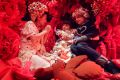Lily and Nina Vujovic sit beside artist Hiromi Tango inside her art installation the Red Room.