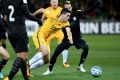 Tom Rogic of the Socceroos breaks through a desperate Thai defense at AAMI Park on Tuesday night. 