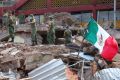 Soldiers remove debris from a partly collapsed municipal building felled by a massive earthquake in Juchitan, Oaxaca ...