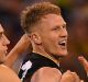 Richmond players celebrate with Josh Caddy (centre) after he kicks a goal in the qualifying final win over Geelong on Friday.