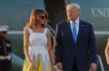 In this August 20, 2017 photo, President Donald Trump, first lady Melania Trump and son Barron Trump walk across the ...