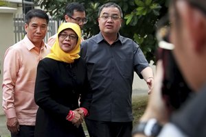 Halimah Yacob, center, leaves the Elections Department on Monday, Sept. 11, 2017, in Singapore. The Elections Department announced that Yacob, a former People’s Action Party politician, will be declared Singapore’s first female president on Wednesday, Sept. 13, as the two other potential candidates fell short of the qualification criteria. (AP Photo/ Nuria Ling, TODAY)