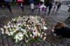 Dozens of memorial candles sit on the cobbled-stone ground