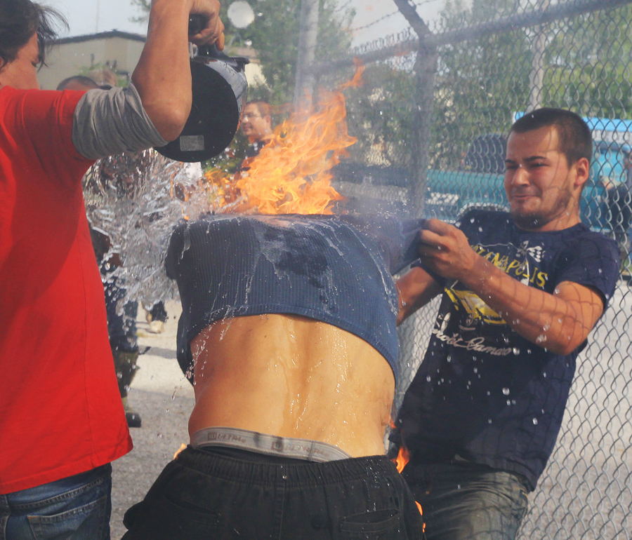 Bystanders assist Pierre George, the brother of killed protester Dudley George, who is engulfed in flames after attempting to pour gasoline on a fire during a protest against a community march intended to "walk home" to the gates of the former Camp Ipperwash on Sunday, Sept. 20, 2015, in London, Ontario. The land is being returned to the Kettle and Stony Point First Nation after being expropriated by the Federal government during the Second World War. THE CANADIAN PRESS/Dave Chidley