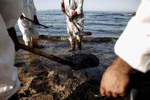 Workers clean a beach from an oil spillage at Faliro suburb, near Athens, on Thursday,Sept. 14, 2017.