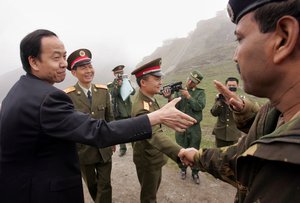 Chinese officials, left, and Indian Army official Brig. S.L. Narasimhan, right, exchange greetings as the Chinese team crosses back to their country at the international border at Nathu La Pass, in the northeastern Indian state of Sikkim, Wednesday, July 5, 2006