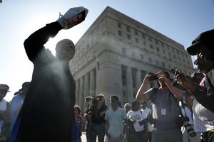 Anthony Shahid, left, speaks out as protesters gather outside of the courthouse, Friday, Sept. 15, 2017, in downtown St. Louis, after a judge found a white former St. Louis police officer, Jason Stockley, not guilty of first-degree murder in the death of a black man, Anthony Lamar Smith, who was fatally shot following a high-speed chase in 2011. (AP Photo/Jeff Roberson)