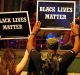 Protesters hold up signs during protests which turned ugly.