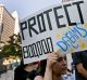 FILE - In this Sept. 1, 2017 file photo, a woman joins a rally in support of the Deferred Action for Childhood Arrivals, ...