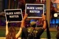 Protesters hold up signs during protests which turned ugly.