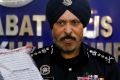 Kuala Lumpur police chief Amar Singh holds up the belongings of a detained suspect.