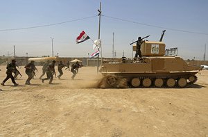 FILE - In this July 18, 2017 file photo, Shiite Volunteer fighters from the Imam Ali Brigade, an armed faction with the Iraqi Popular Mobilization Forces, train at their camp, in Najaf, 100 miles (160 kilometers) south of Baghdad, Iraq.