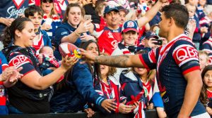 Last man: Latrell Mitchell giving a Roosters football to a new mum for her baby.