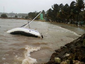 A boat lays on its side off the shore of Sainte-Anne on the French Caribbean island of Guadeloupe, early Tuesday, Sept. 19, 2017, after the passing of Hurricane Maria.