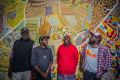 Muuki, Ignatius, Nola and Curtis Taylor stand in front of the painting Yarrakalpa. 