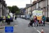 Women push their strollers past a police cordon