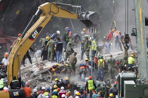 Rescue personnel work on a collapsed building, a day after a devastating 7.1 earthquake, in the Del Valle neighborhood of Mexico City, Wednesday, Sept. 20, 2107.