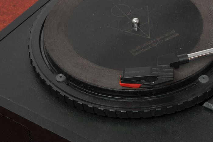 A plan black record sits on a plain black record player.