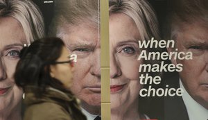 A woman walks by banners of Democratic presidential candidate Hillary Clinton and Republican presidential candidate Donald Trump during an election watch event hosted by the U.S. Embassy in Seoul, South Korea, Wednesday, Nov. 9, 2016.