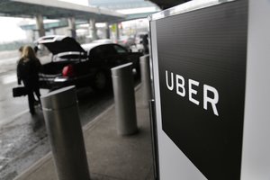 ILE - In this Wednesday, March 15, 2017 file photo, a sign marks a pick-up point for the Uber car service at LaGuardia Airport in New York.