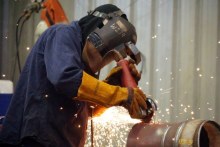 Worker cuts a pipe at Alltype Engineering, Perth, July 2016