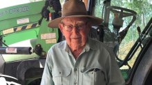 A close-up photo of farmer Max Hockey, who is standing in front of a tractor.