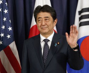 FILE - In this July 6, 2017 file photo, Japanese Prime Minister Shinzo Abe gestures as he meets with U.S. President Donald Trump and South Korean President Moon Jae-in before the Northeast Asia Security dinner in Hamburg.