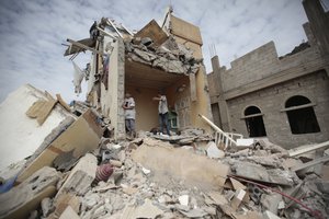 File - Boys stand on the rubble of a house destroyed by Saudi-led airstrikes in Sanaa, Yemen, Friday, Aug. 25, 2017.