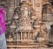 An Indian woman stands next to the carvings on the Khajuraho Temples in Madhya Pradesh, India. 