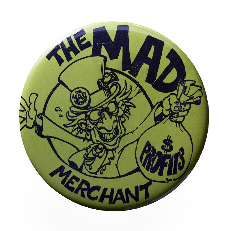 A pin reading “The Mad Merchant” features a mad-hatter like figure celebrating with his profits