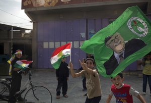 Children holding Kurdish flags run on the streets of the disputed city of Kirkuk, Monday Sept. 25, 2017. Iraq's Kurdish region vote in  a referendum on whether to secede from Iraq. (AP Photo/Bram Janssen)