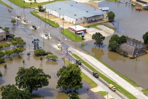 Army tactical vehicles transport flood relief supplies along a highway in Denham Springs, Louisiana, Aug. 15, 2016, after more than 30 inches of rainfall caused severe flooding in southeast portions of the state.