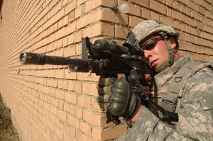 US Army Sgt. Brandon Maybush scans the street through his weapon scope