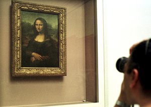 This Monday, April 26, 2004 file photo shows a man taking a photograph of Leonardo da Vinci's 16th century masterpiece the "Mona Lisa" painting, kept behind a protective glass, in the Louvre museum in Paris