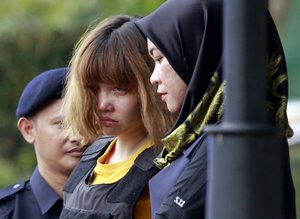 Vietnamese suspect Doan Thi Huong, center, in the ongoing assassination investigation, is escorted by police officers out from Sepang court in Sepang, Malaysia on Wednesday, March 1, 2017. Appearing calm and solemn, two young women accused of smearing VX nerve agent on Kim Jong Nam, the estranged half brother of North Korea's leader, were charged with murder Wednesday. (AP Photo/Daniel Chan)