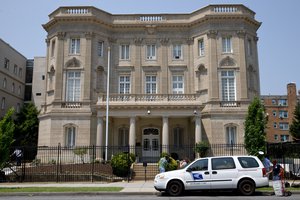 A U.S. Postal Service worker unloads packages in front of the Cuban Interests Section, which serves as the de facto diplomatic mission of Cuba to the United States, Wednesday, July 1, 2015 in Washington.