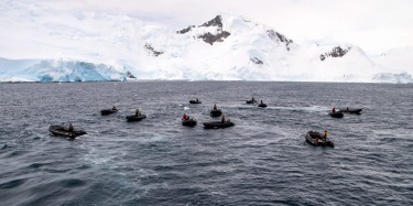 12 expedition guides awaiting patiently in their zodiacs as we eagerly queue to board them to start our morning ...