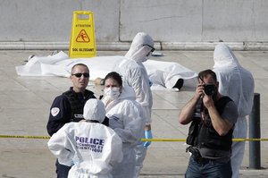 Investigative police officer work by a body under a white sheet outside Marseille 's main train station Sunday, Oct. 1, 2017 in Marseille, southern France.