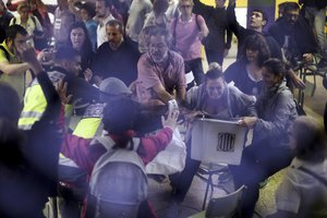 Spanish National Police officers in plain clothes try to snatch a ballot box from polling station officials at the Ramon Llull school assigned to be a polling station by the Catalan government in Barcelona, Spain, early Sunday, Oct. 1, 2017.