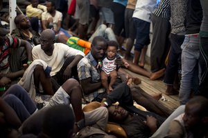 File - A man from Nigeria holds a 5 months old baby, on their way to Italy at the rescue vessel Golfo Azzurro, after being rescued by Spanish NGO Proactiva Open Arms workers on the Mediterranean Sea on Friday, June. 16, 2017.