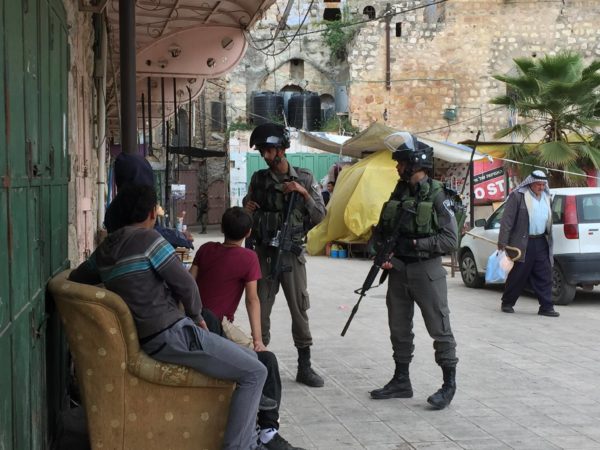 A group of Palestinian boys are questioned by Israeli Border Police in the souk, al-Khalil’s Old Town.