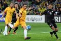 Patience please: Mark Milligan of the Socceroos strikes the ball but fails to break through against Thailand.