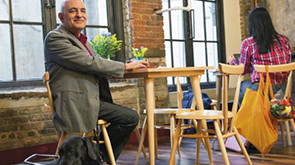 Smiling man sitting at table in indoor cafe