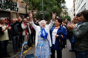 An elderly lady is applauded as she celebrates after voting at a school assigned to be a polling station by the Catalan ...