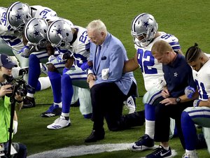 The Dallas Cowboys, led by owner Jerry Jones, center, take a knee prior to the national anthem prior to an NFL football game against the Arizona Cardinals, Monday, Sept. 25, 2017, in Glendale, Ariz.