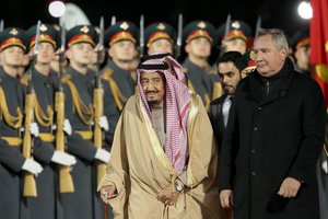 Saudi King Salman, center, and Russian Deputy Prime Minister Dmitry Rogozin, right, review an honor guard upon arrival in Moscow's Government Vnukovo airport, Russia, Wednesday, Oct. 4, 2017.