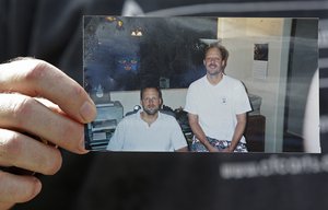 Eric Paddock, brother of  Las Vegas gunman Stephen Craig Paddock, holds up a photo of he and his brother outside his home, Monday, Oct. 2, 2017, in Orlando, Fla. Eric Paddock is on the left.