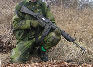 Example of safe firearm handling. The firearm is pointed at the ground and the handler's finger is off the trigger.